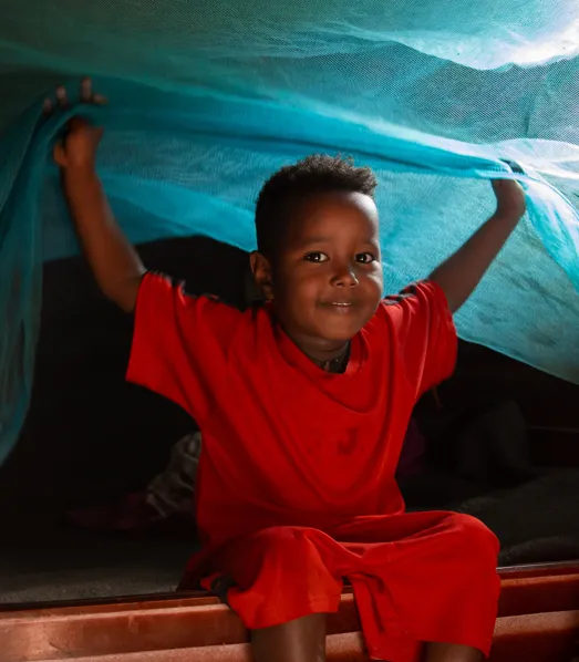 Genet chalew's child plays on a bed covered by mosquito net in Bilate chericho Kebele, South Ethiopia (c) Amref Health Africa / Genaye Eshetu