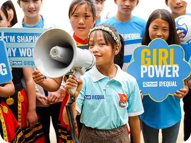 Een meisje heeft een megafoon vast en is omringd door andere meisjes die allemaal pancartes dragen met verschillende leuzen zoals: “Girl Power”